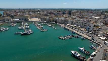 Fototapeta premium Aerial view of the port of the city of Trani, in Puglia, Italy. It is a small tourist seaport on the Adriatic Sea. There are many boats anchored in the clean water of the harbour.