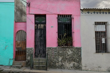 Bubblegum pink facade flanked by turquoise and white walls, house on Calle Maceo Street west-even numbers side in Regla municipality. Havana-Cuba-648