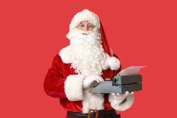 Santa Claus with vintage typewriter on red background