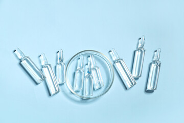Medical ampules with petri dish on blue background