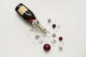 Fototapeta na wymiar Bottle of champagne with Christmas balls and confetti on white background