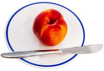 Ripe fresh red nectarine with knife on plate. Healthy eating. Isolated over white background