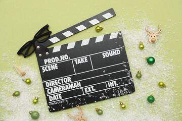 Composition with movie clapper, 3D glasses and Christmas decorations on green background. Top view
