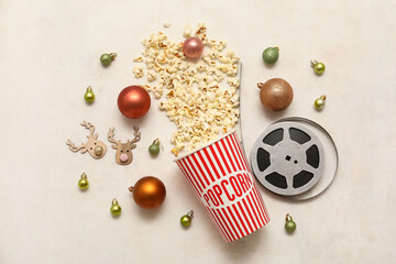 Composition with bucket of popcorn,  film reel and Christmas decorations on white background. Top...