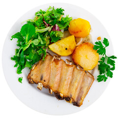 Delicious pork ribs with boiled potatoes and fresh salad leaves. Isolated over white background