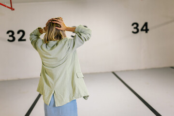 Stressed woman searching for her car on an underground parking.