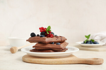 Plate of sweet chocolate Belgian waffles with fresh berries and mint on white background