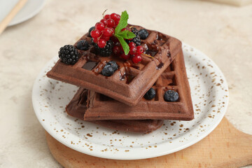 Plate of sweet chocolate Belgian waffles with fresh berries and mint on white background