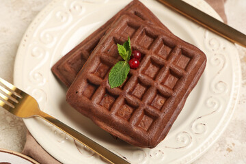 Plate of sweet chocolate Belgian waffles with fresh red currants and mint on white background