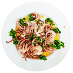 Ready to serve tasty baby octopus tentacles with greens on white plate. Isolated over white background