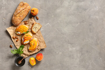 Baking paper of peach bruschetta with ricotta, basil, almond nuts and bowl of honey on grey background