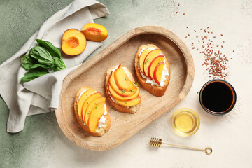 Wooden tray of peach bruschetta with ricotta, basil and flax seeds on grunge background