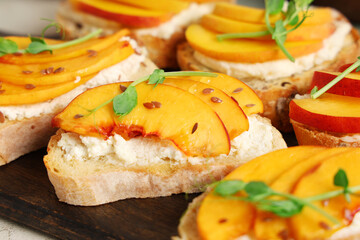 Wooden board of peach bruschetta with ricotta, flax seeds and micro green, closeup