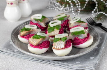 Eggs stuffed with beets and salted herring, garnished with parsley and onion