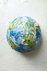A round cake designed to resemble the Earth, placed on a white surface