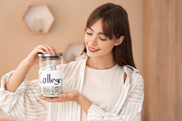 Female student with jar of money for college at home. Education savings concept