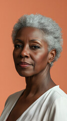 Obraz premium Elegant mature woman with grey hair and sophisticated makeup poses against an orange backdrop