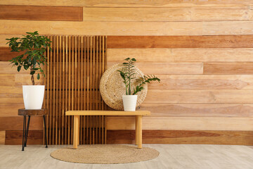 Stylish interior of living room with bench, houseplants and folding screen