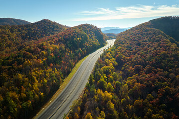 Aerial view of empty I-40 freeway in North Carolina leading to Asheville through Appalachian mountains in golden fall season. Energy crisis and high gas prices concept