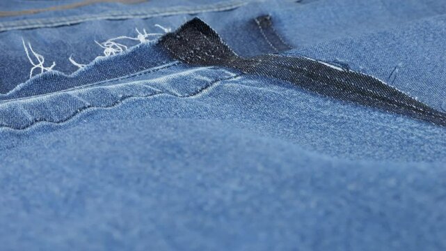 Soft folds of light blue denim fabric rotate on the showcase. Design, fashion, tailoring of comfortable casual wear from natural fabrics. Textile background.