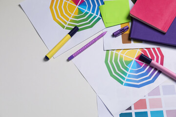 Designer's workplace with different palettes and stationery on white table, flat lay. Space for text