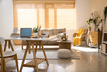 Interior of living room with programmer's workplace, sofa and armchair