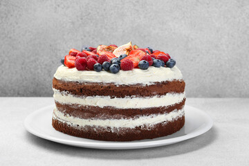 Delicious chocolate sponge cake with berries on light table