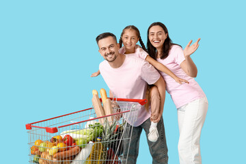 Happy family with full shopping cart having fun on blue background