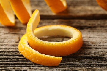 Fresh orange peels on wooden table, closeup