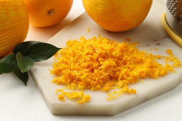 Fresh orange zest and fruits on light table, closeup