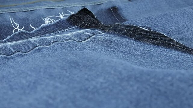 Soft folds of bright blue denim fabric rotate on the showcase. Design, fashion, tailoring of comfortable casual wear from natural fabrics. Textile background.