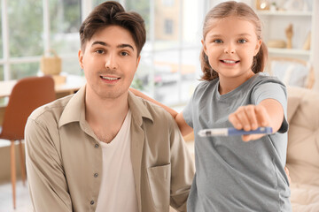 Diabetic girl with lancet pen and her father at home