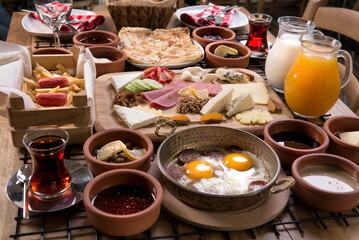 Traditional delicious modern Turkish cuisine. Plain Turkish breakfast with copper-pan egg dishes, pastries such as börek and bagels, jams, olives, cheeses, vegetables and Turkish tea.