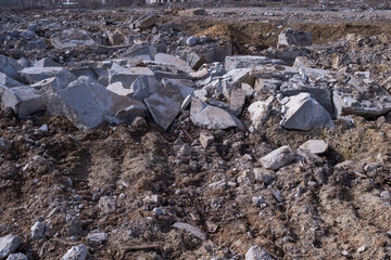 Gray fragments of concrete from the remains of destroyed buildings are scattered on the ground throughout the field of the frame. Background
