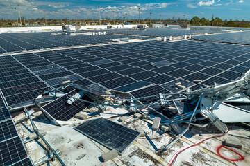 Broken down photovoltaic solar panels destroyed by hurricane Ian winds mounted on industrial...