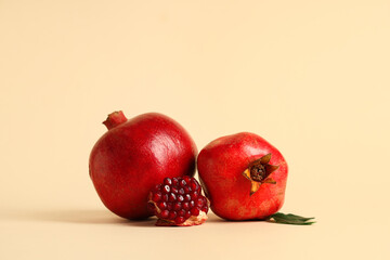 Fresh ripe pomegranates and leaves on yellow background