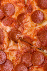 Pepperoni pizza with sausage, mozzarella cheese, tomatoes, salt and spices