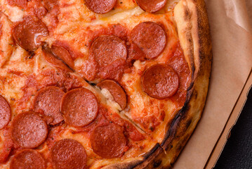 Pepperoni pizza with sausage, mozzarella cheese, tomatoes, salt and spices