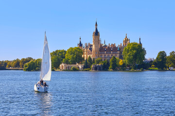 Schöner Blick auf das berühmte Schweriner Schloss, mit Segelboot im Vordergrund, in Deutschland, Mecklenburg-Vorpommern.