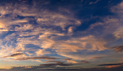 Colorful sunset sky with setting sun behind vivid orange and yellow clouds