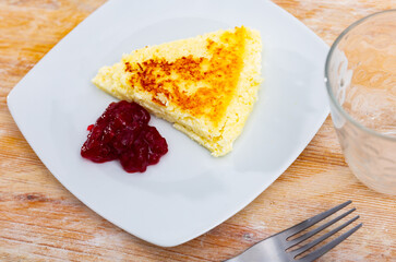 Appetizing piece of cottage cheese casserole served with jam for dessert