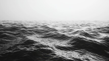 A monochromatic image of undulating waves in the ocean, blending softly into a hazy horizon, evoking tranquility and the vastness of nature.