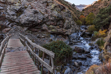 Bridge over the Guarnon River, on the La Estrella trail, with the peak of Veleta looming in the background, Sierra Nevada, Granada.