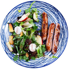 Grilled sausages with salad, walnuts and raisins. Isolated over white background
