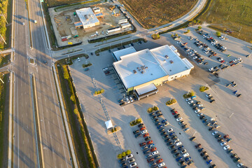 View from above of dealers outdoor parking lot with many brand new cars in stock for sale on...
