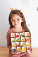a girl plays a game developing mantessori polymer vegetables.