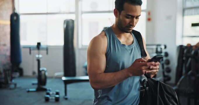Man, gym and texting on smartphone for fitness with exercise, training and workout. Male person, body builder and internet or online for social media, message and communication with networking