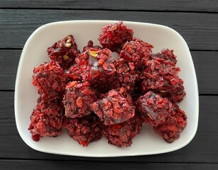 Turkish Delight with berberis vulgaris on black background isolated, close up rose Turkish Delight. Turkish delight with dried berberis fruit on wooden background. Traditional Turkish cuisine flavors.