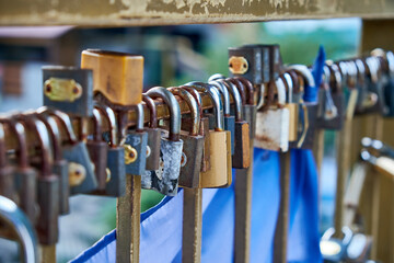 A multiple padlocks attached to a metal railing