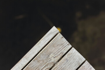 Wooden corner of the bridge, diving boards over the water. Background, photo, top view.